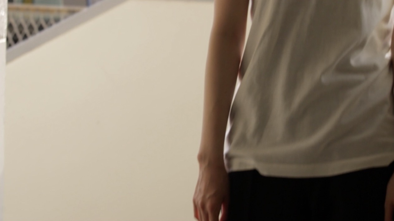 外廊下に立つ白いTシャツの人