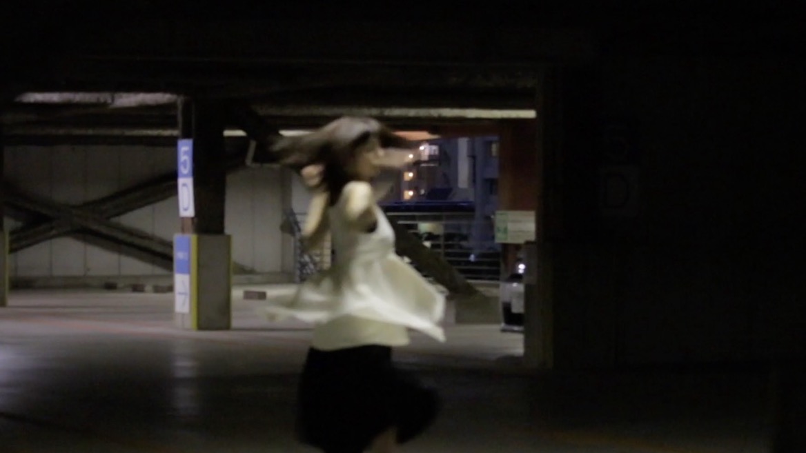 夜の駐車場でくるくる回る人